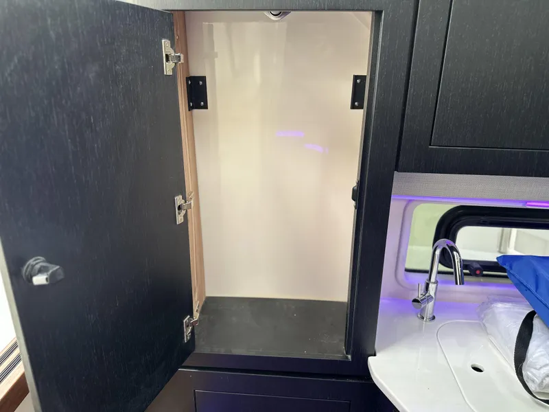 Slide: The Image of Open cabinet in 2025 Boston Whaler 380 Realm boat interior, featuring modern design and sink. - 21
