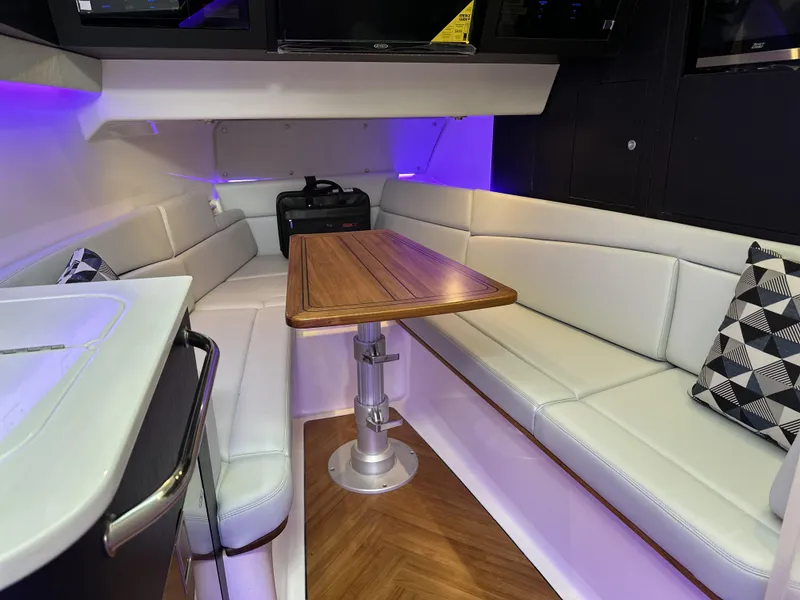 Slide: The Image of 2025 Boston Whaler 380 Realm interior with modern seating and wooden table. - 23