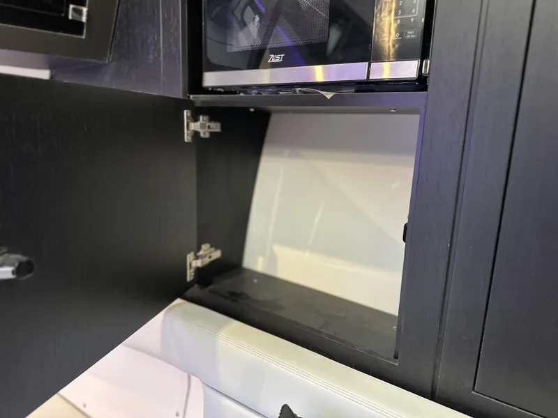 Slide: The Image of Open cabinet on 2025 Boston Whaler 380 Realm boat, showcasing interior storage space. - 24