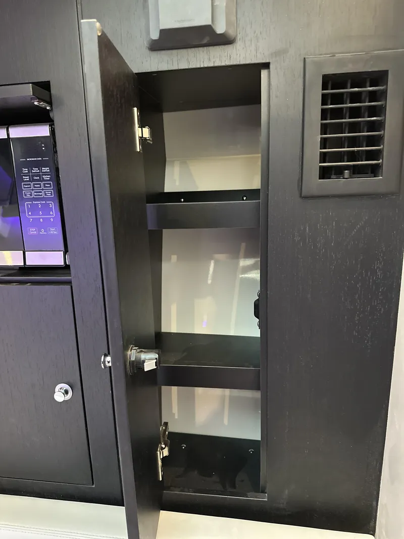Slide: The Image of Open storage cabinet inside a 2025 Boston Whaler 380 Realm boat. - 25