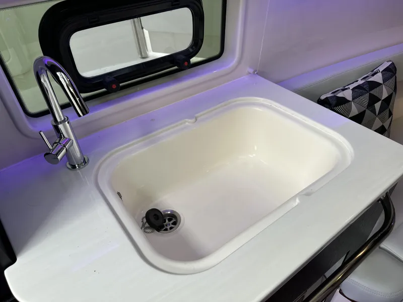 Slide: The Image of 2025 Boston Whaler 380 Realm interior sink with modern faucet and window view. - 26