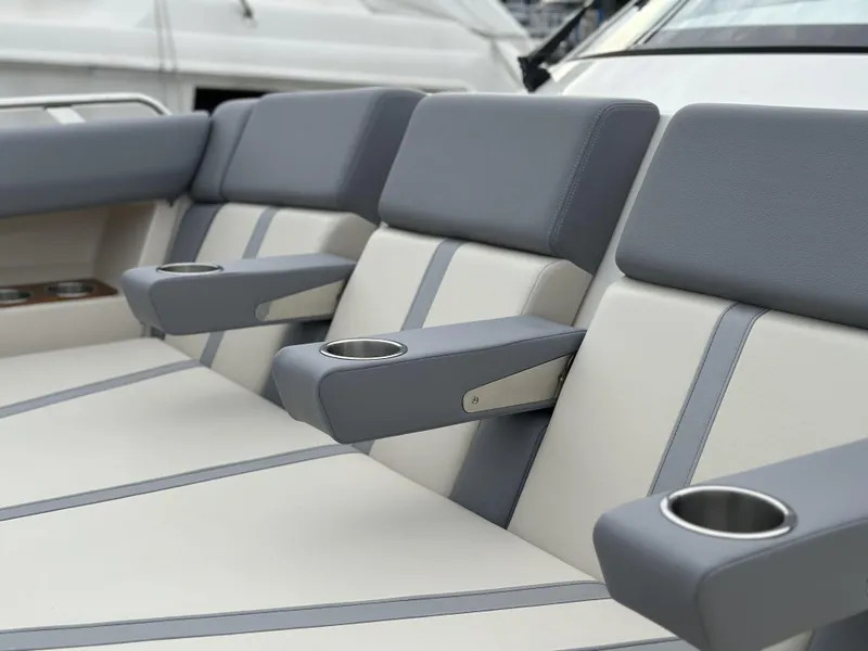 Slide: The Image of 2025 Boston Whaler 380 Realm boat seats with cup holders, featuring gray and white upholstery. - 33