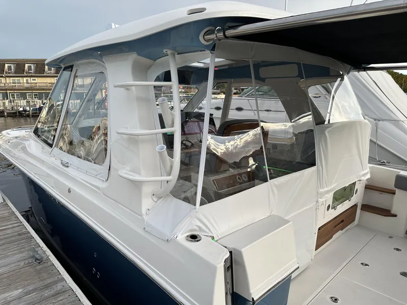 Slide: The Image of 2025 Boston Whaler 380 Realm boat docked, featuring sleek design and spacious cabin. - 4