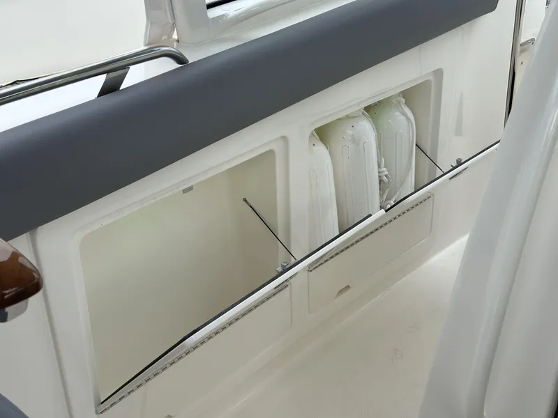Slide: The Image of 2025 Boston Whaler 380 Realm interior storage compartment with life jackets. - 40