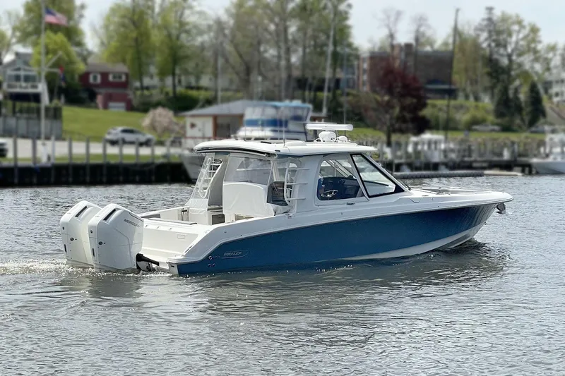 Slide: The Image of 2025 Boston Whaler 380 Realm boat cruising on a calm river. - 44