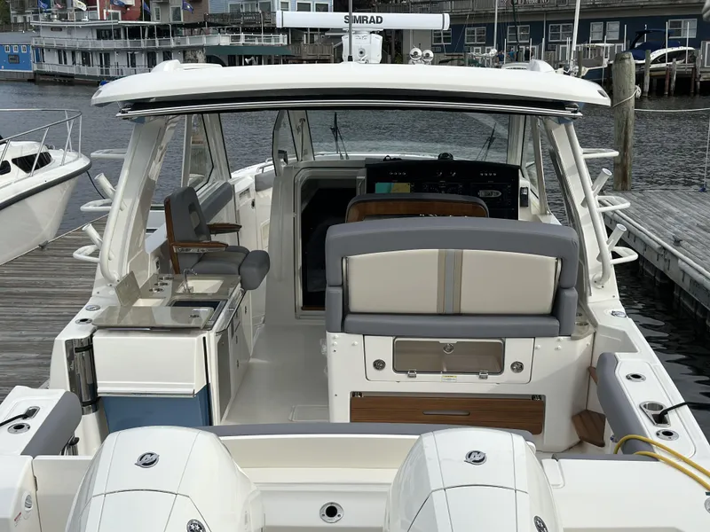 Slide: The Image of 2025 Boston Whaler 380 Realm boat docked, showcasing spacious seating and modern amenities. - 6