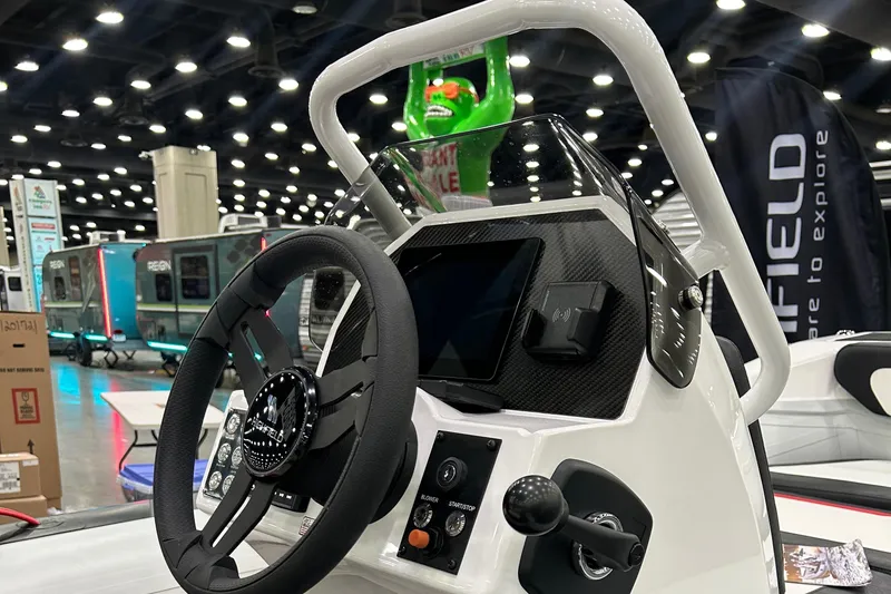 Slide: The Image of Highfield Velox 420 boat dashboard, 2025 model, featuring steering wheel and control panel at a boat show. - 10