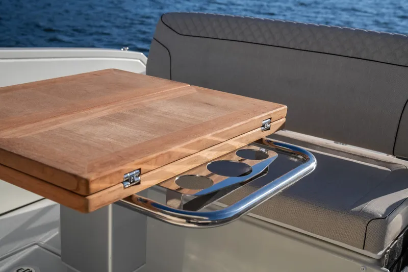 Slide: The Image of Luxury Catamaran YOT 36, 2025 model, featuring a wooden table and cushioned seating. - 14