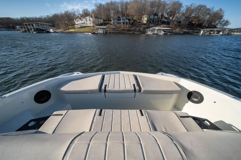 Slide: The Image of Catamaran YOT 36 (2025) with spacious seating, overlooking serene lake and shoreline homes. - 22