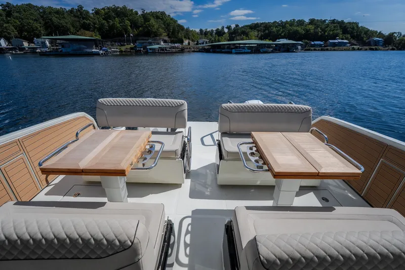 Slide: The Image of Luxurious 2025 Catamaran YOT 36 deck with seating and tables on a serene lake. - 18