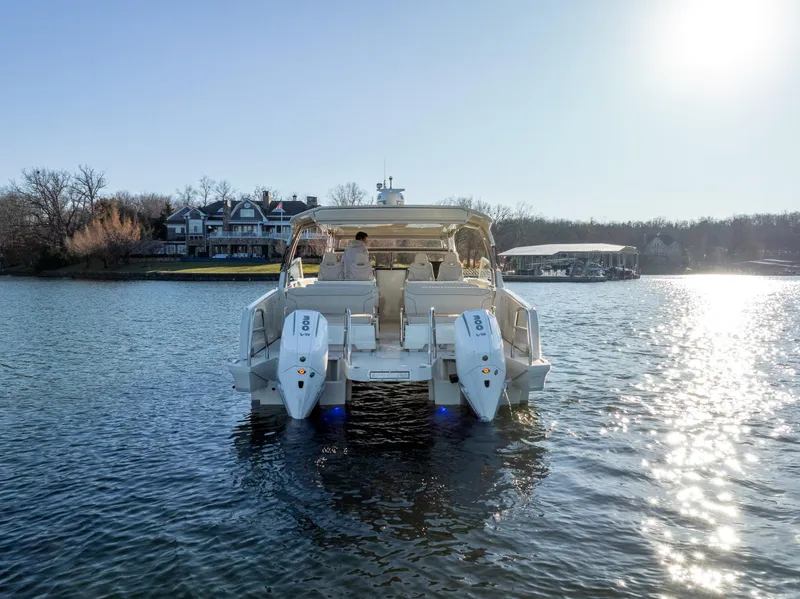 Slide: The Image of 2025 Catamaran YOT 36 on serene lake, sunny day, waterfront house in background. - 4