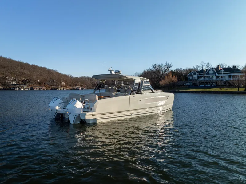 Slide: The Image of 2025 Catamaran YOT 36 on serene lake near shoreline homes. - 5