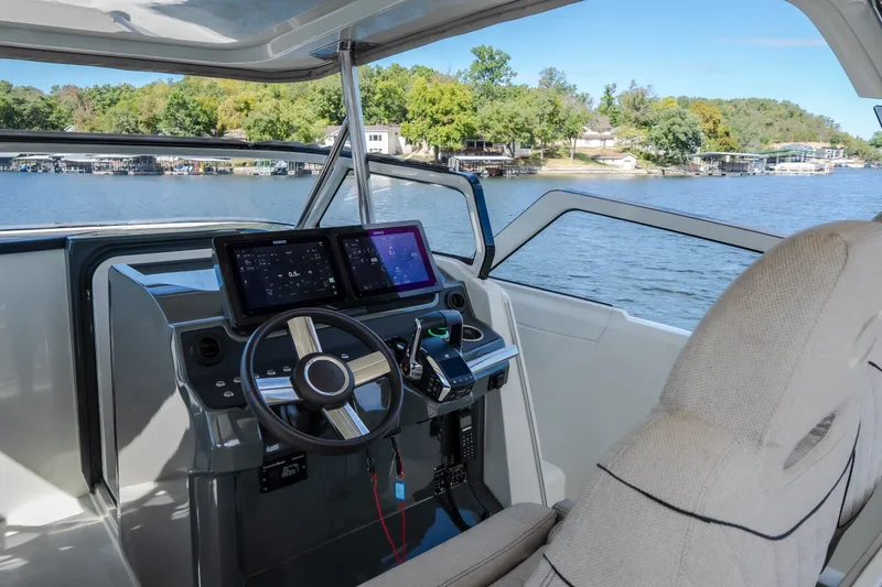 Slide: The Image of Modern helm of 2025 Catamaran YOT 36 with dual screens, steering wheel, and lake view. - 35