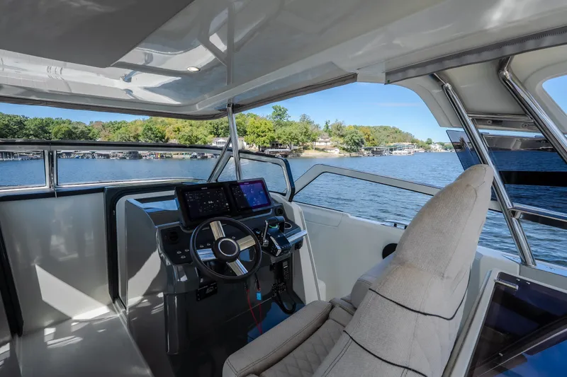 Slide: The Image of Modern helm of 2025 Catamaran YOT 36 with dual screens, overlooking serene waters. - 36