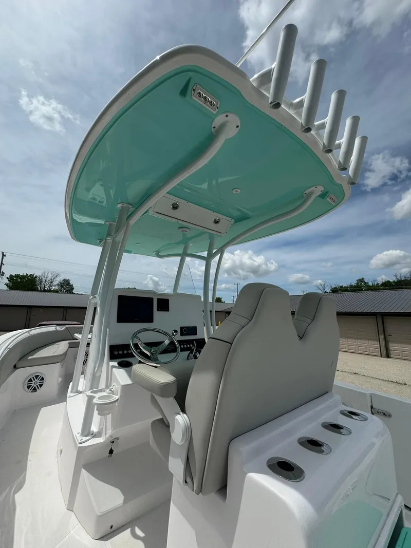 Slide: The Image of 2022 Streamline Center Console boat with modern helm and rod holders under a blue sky. - 12
