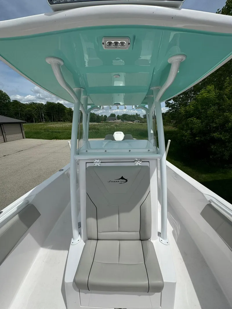 Slide: The Image of 2022 Streamline Center Console boat with teal canopy and cushioned seating. - 18