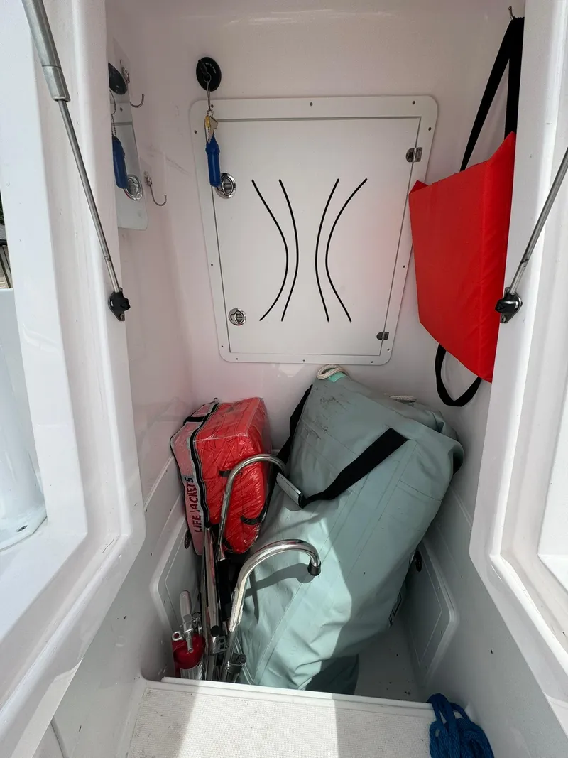 Slide: The Image of Storage compartment in 2022 Streamline Center Console boat with safety gear and equipment. - 19