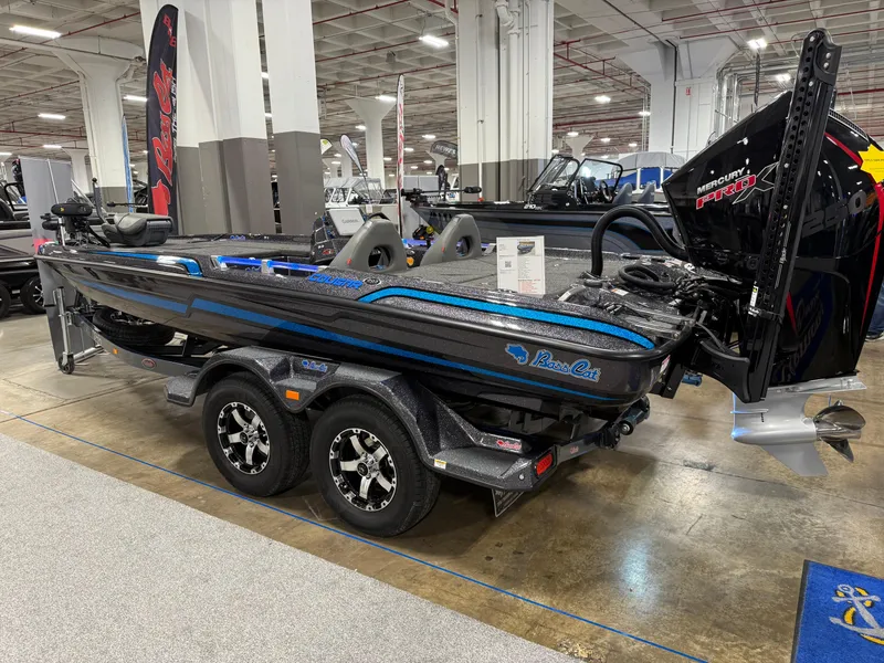 Slide: The Image of 2025 Bass Cat Cougar FTD boat displayed indoors, featuring sleek design and powerful engine. - 13