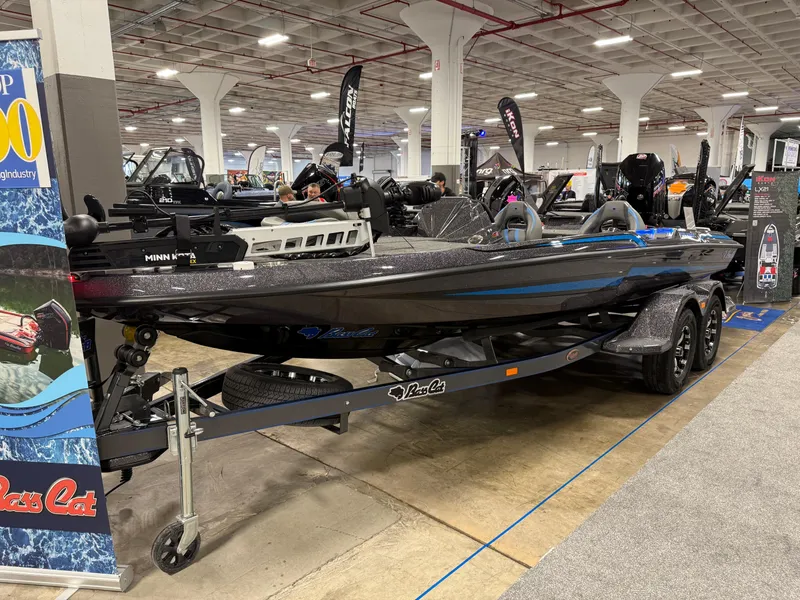 Slide: The Image of 2025 Bass Cat Cougar FTD boat on display in an indoor showroom. - 14
