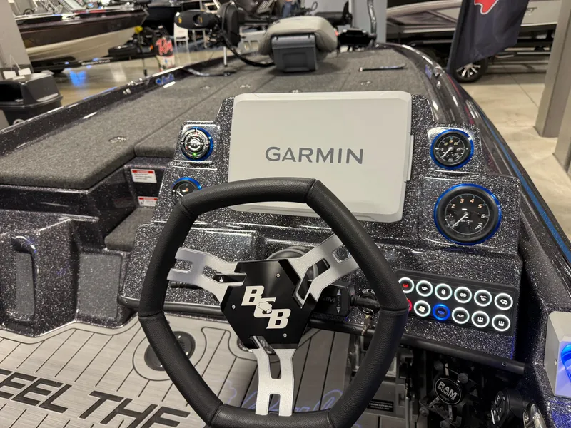 Slide: The Image of 2025 Bass Cat Cougar FTD boat dashboard with Garmin display and steering wheel. - 16