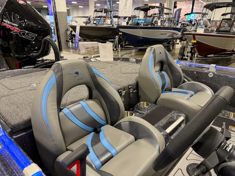 Slide: The Image of 2025 Bass Cat Cougar FTD interior with blue and gray seats at a boat show. - 17