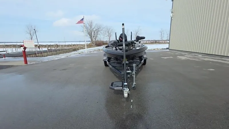 Slide: The Image of 2025 Bass Cat Cougar FTD boat on trailer, parked outdoors near a building. - 22