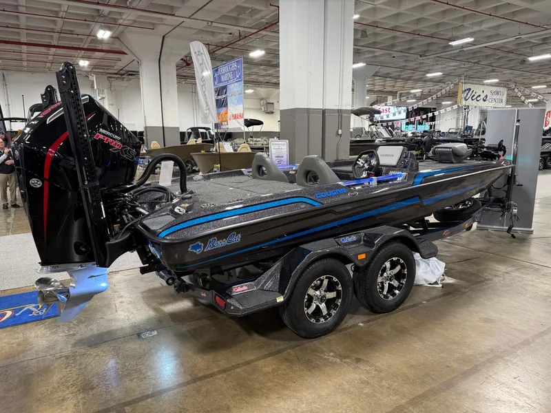 Slide: The Image of 2025 Bass Cat Cougar FTD boat on display in an indoor showroom. - 3
