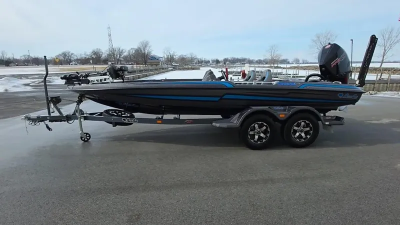 Slide: The Image of 2025 Bass Cat Cougar FTD boat on trailer, parked on a snowy day. - 6