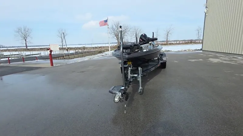 Slide: The Image of 2025 Bass Cat Cougar FTD boat on trailer, parked outdoors near a building. - 9