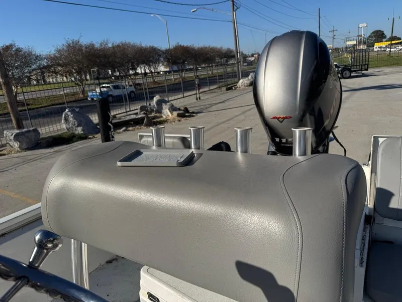 Slide: The Image of 2021 Avid 21 FS boat with motor and rod holders in a parking area. - 15
