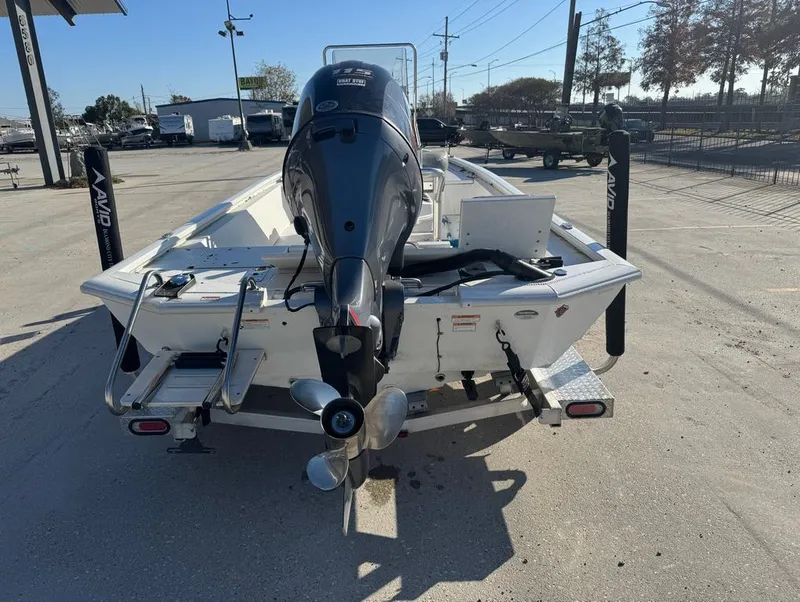 Slide: The Image of 2021 Avid 21 FS boat with outboard motor, parked on a trailer. - 4