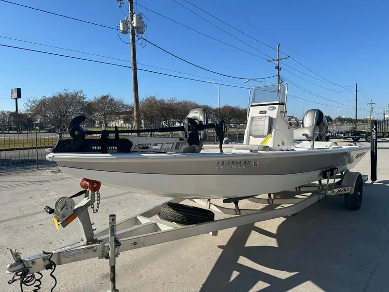 Slide: The Image of 2021 Avid 21 FS boat on trailer, parked outdoors under clear blue sky. - 7