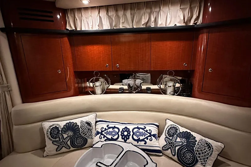 Slide: The Image of Luxurious 2002 Sea Ray 320 Sundancer cabin with elegant wood cabinetry and nautical-themed cushions. - 7