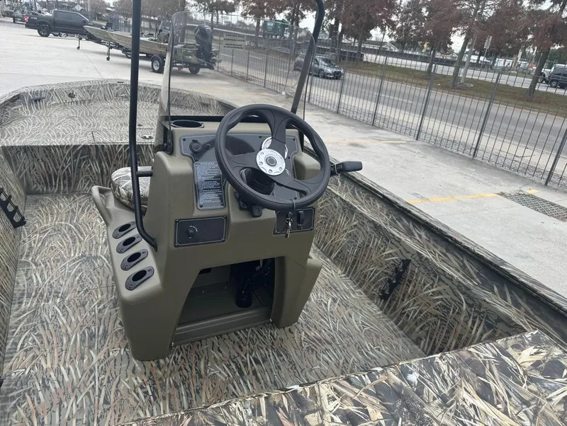 Slide: The Image of 2025 Tracker 1860 Grizzly boat with camo interior and steering console. - 8