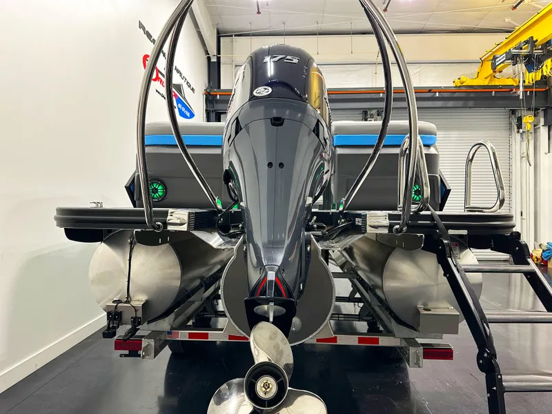 Slide: The Image of 2025 Bennington 22 MFBSE pontoon boat with powerful outboard motor in a showroom. - 3