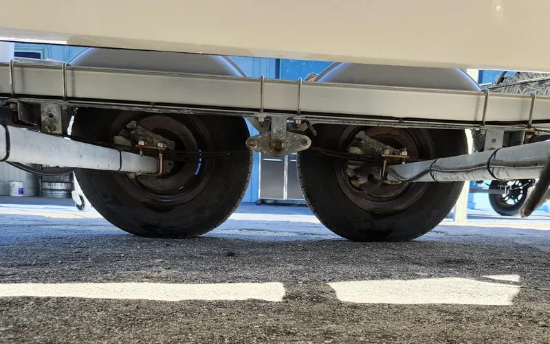 Slide: The Image of Trailer wheels of a 2019 Mako 184 CC boat on pavement. - 25