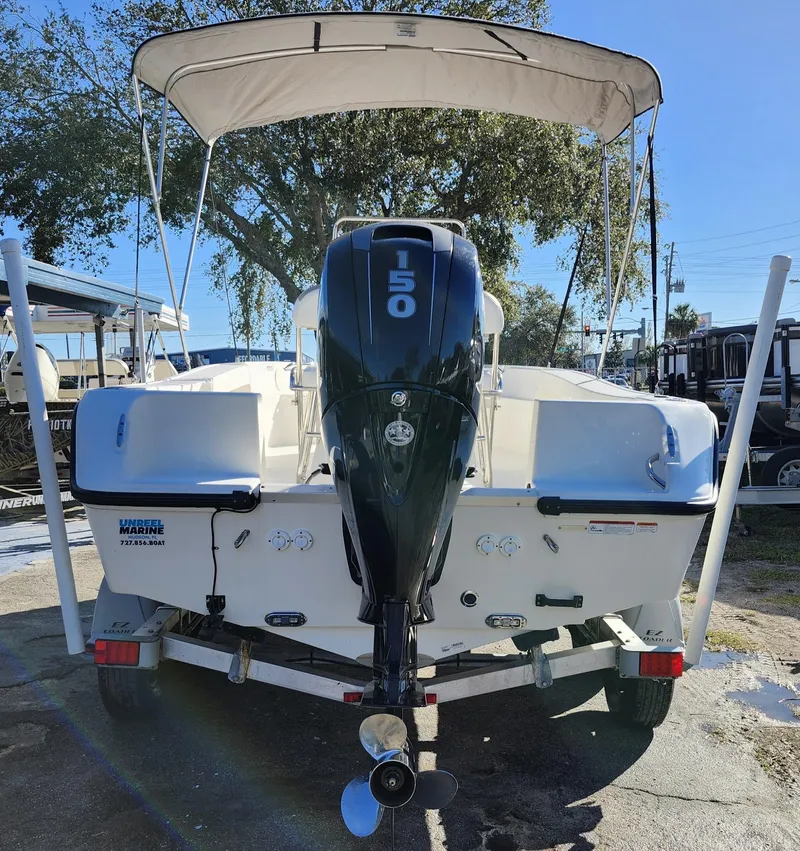 Slide: The Image of 2019 Mako 184 CC boat with 150 HP engine, parked outdoors under canopy. - 5