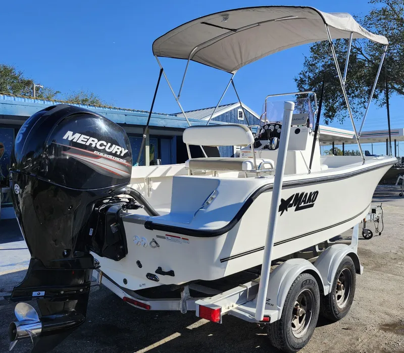 Slide: The Image of 2019 Mako 184 CC boat with Mercury engine on trailer, parked outdoors. - 6