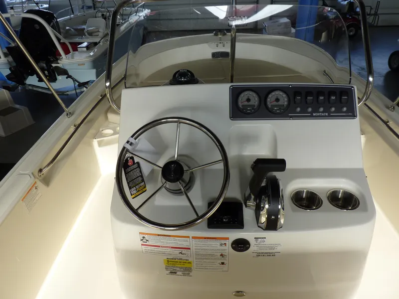 Slide: The Image of 2025 Boston Whaler 190 Montauk boat dashboard with steering wheel and controls. - 9