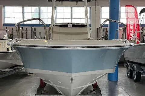 Slide: The Image of 2025 Boston Whaler 220 Dauntless boat in showroom, front view. - 2