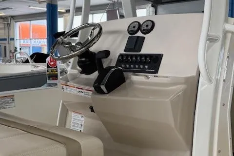Slide: The Image of 2025 Boston Whaler 220 Dauntless boat console with steering wheel and controls. - 5