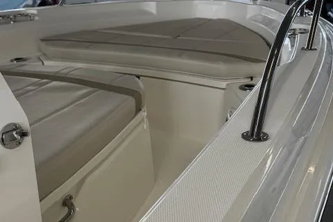 Slide: The Image of 2025 Boston Whaler 220 Dauntless boat interior with cushioned seating and stainless steel railings. - 7