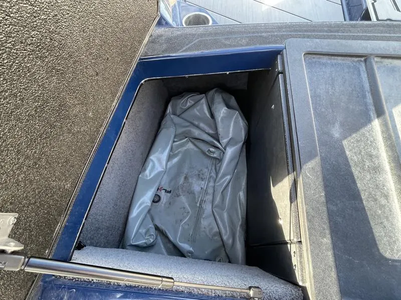 Slide: The Image of 2017 Malibu 21 VLX storage compartment with gray cover inside. - 24