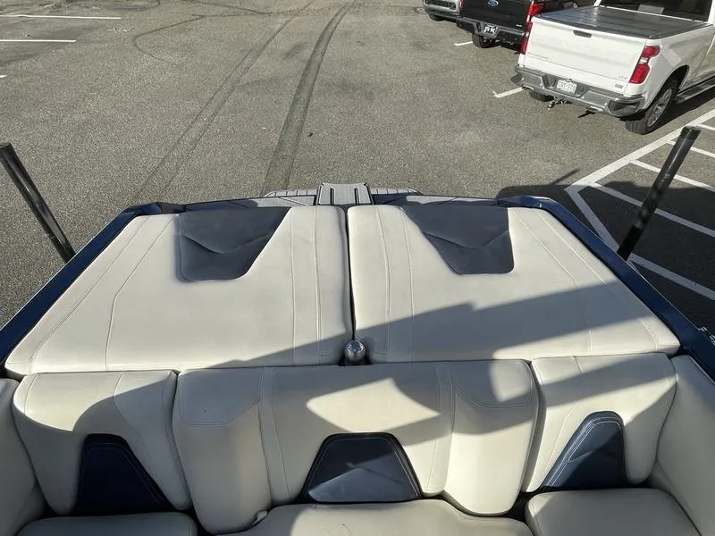 Slide: The Image of 2017 Malibu 21 VLX boat interior with white and gray seating in a parking lot. - 28