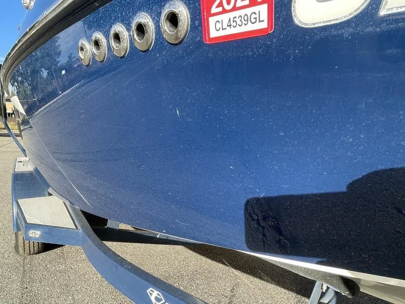 Slide: The Image of 2017 Malibu 21 VLX boat on trailer, blue hull with registration sticker. - 33