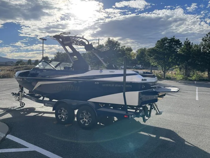 Slide: The Image of 2017 Malibu 21 VLX boat on trailer in sunny parking lot. - 4
