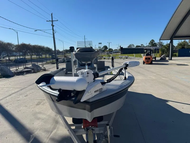 Slide: The Image of 2024 Avid 21 FS Platinum boat with Minn Kota trolling motor in a parking lot. - 13