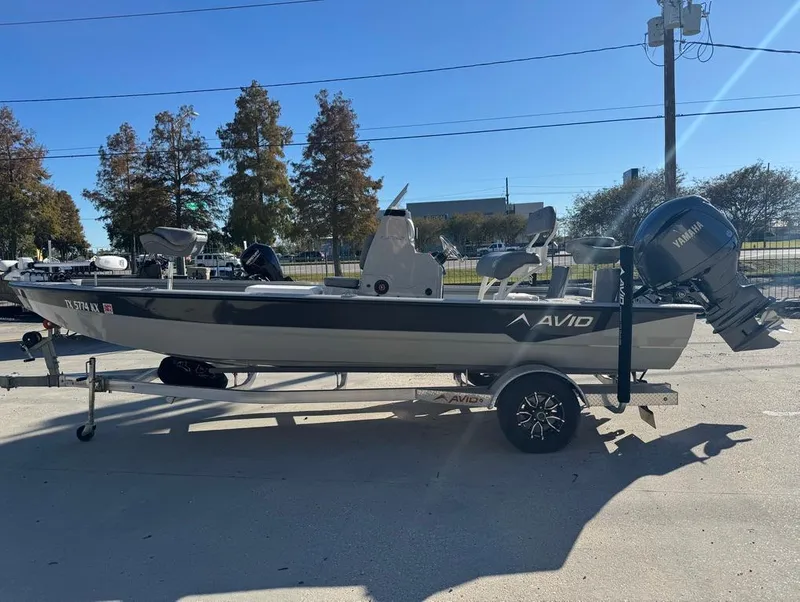 Slide: The Image of 2024 Avid 21 FS Platinum boat on trailer with Yamaha engine, parked outdoors. - 4
