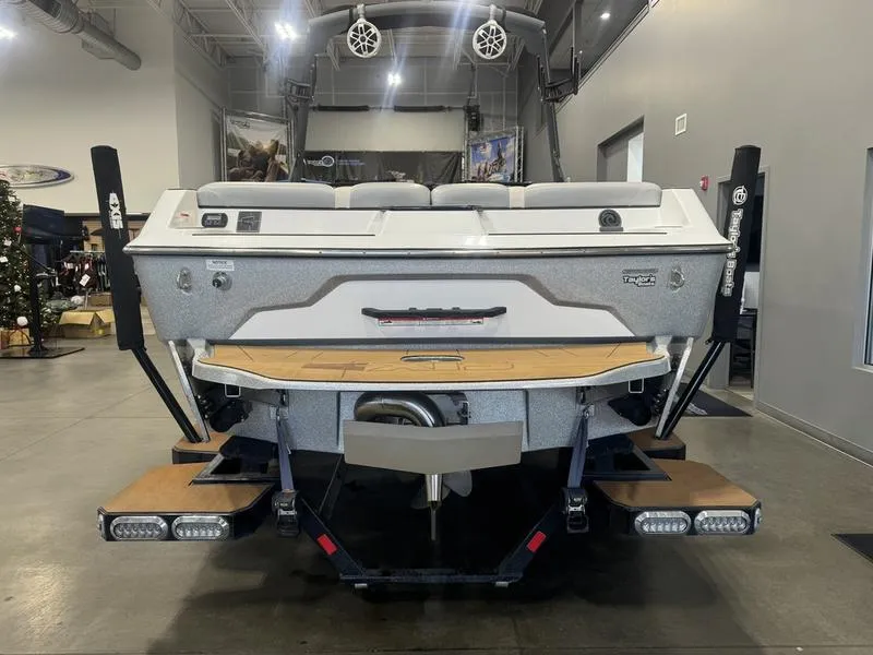 Slide: The Image of 2022 Axis A22 boat rear view in showroom with swim platform and speakers. - 4