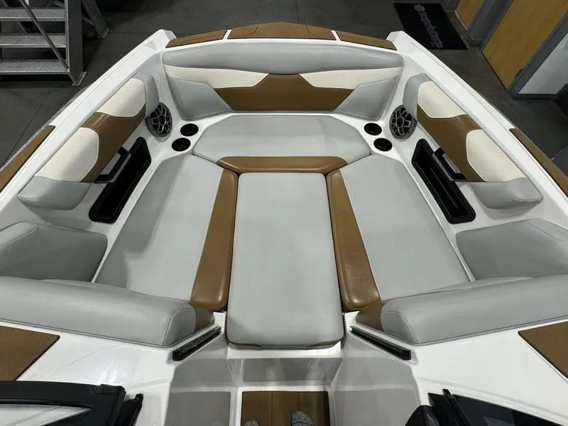 Slide: The Image of 2022 Axis A22 boat interior with gray and brown seating, cup holders, and speakers. - 8